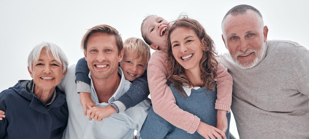 A joyful multi-generational family group smiling and embracing, representing the comprehensive dental care at Renewal Family Dental.